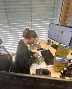 Jule bereitet die Kuchen Hubert Kartons zum Versand vor